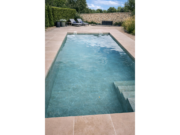 Pool mit Treppe und armierter Poolfolie Cefil Victoria Aurum neben einer Steinmauer