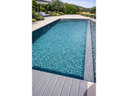 Pool mit blauem Wasser und armierter Poolfolie Cefil Nature Ciclon, mit grauer Holzterrasse