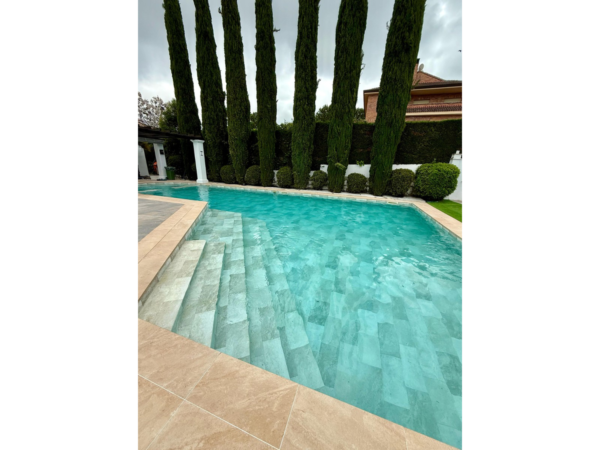 Pool mit Treppe und armierter Poolfolie Cefil Keramik Sunlight zwischen hohen Zypressen
