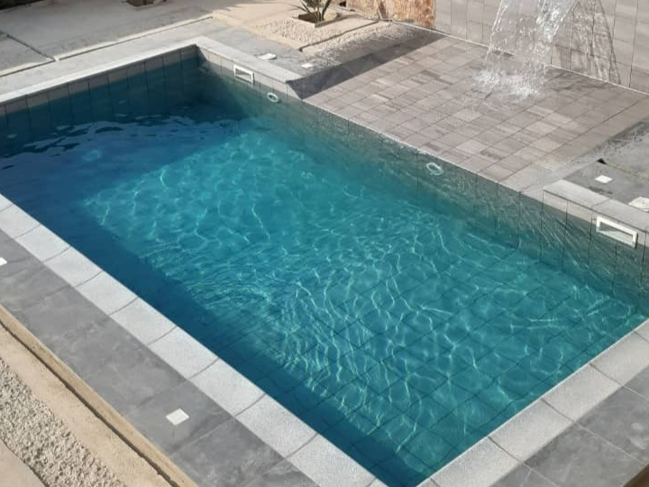 Rustic coping stone around a rectangular pool