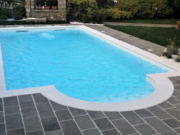 Toro XL coping stone around a pool with a Roman staircase