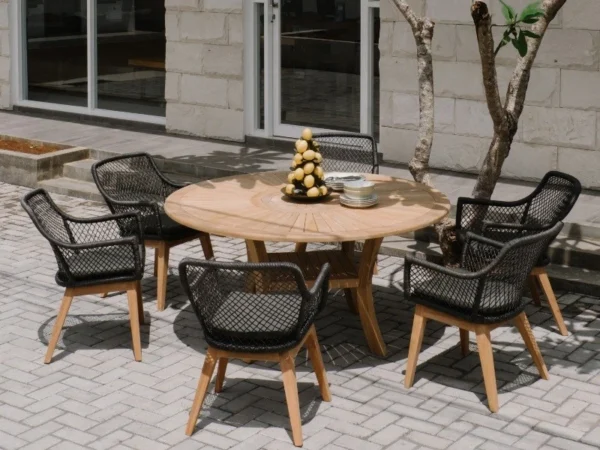 Sechs schwarze Sessel Olivia um einen runden Teaktisch mit drehbarer Mitte auf einer Terrasse