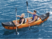 Δύο άτομα κωπηλατούν σε φουσκωτό καγιάκ Lite-Rapid X2 στη θάλασσα