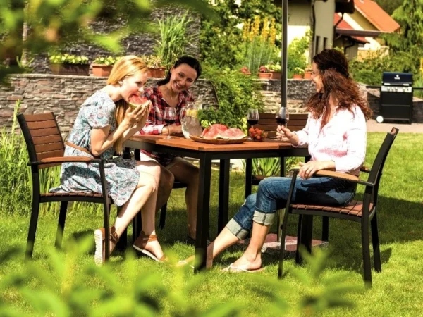 Friends around a Flamingo garden table on the grass in the garden