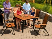 Guests around a Flamingo garden table on a sunny terrace