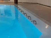 Flexstone stone overflow grate around an indoor pool