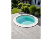 Runder Pool MTH Atlantic Round mit sandfarbener Auskleidung auf einer Terrasse aus grauen Platten neben dem Haus