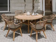 Colosseum round garden table with six Olivia armchairs on a paved terrace
