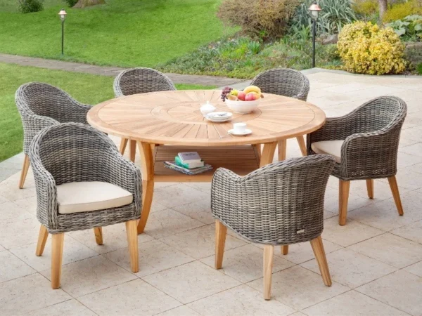 Colosseum round garden table with gray wicker armchairs and books on the shelf