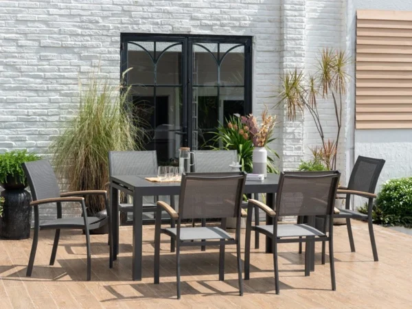 Tisch Essence mit Stühlen auf einer Terrasse vor einer weißen Backsteinwand