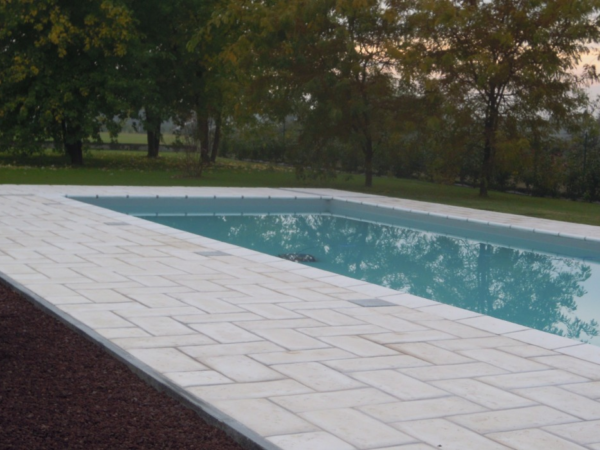 Weißer Belag Piedra um einen Pool