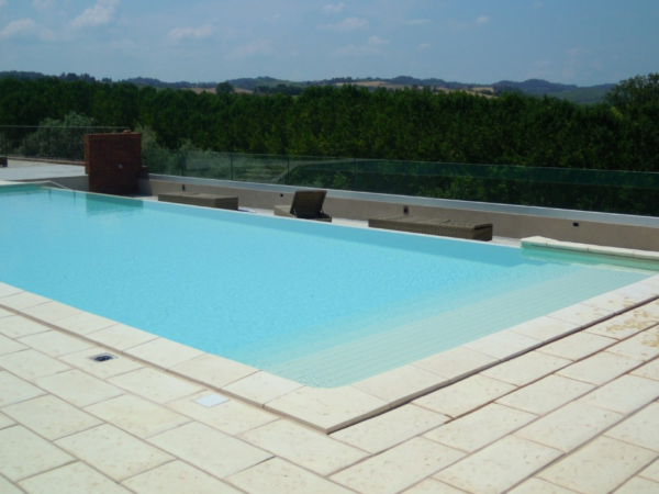 Gelber Belag Piedra um einen Pool