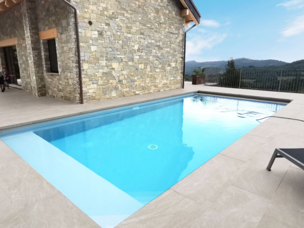 Plăci Harmony în jurul unei piscine lângă o casă din piatră