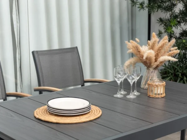 Platte des Tisches Essence mit Tellern, Gläsern und Vase mit Ziergras