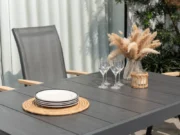 Gedeckter Tisch mit Gläsern und Sessel Essence im Hintergrund