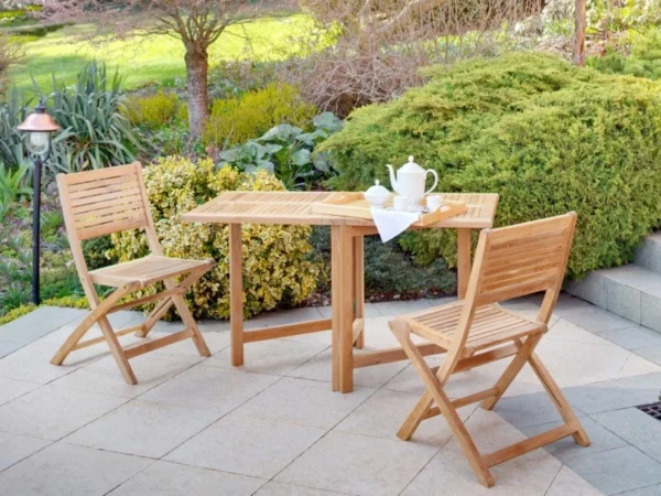 Două scaune pliante de balcon Ambra lângă o masă de lemn pe o terasă în grădină