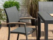 Scaun de grădină Essence pe o terasă însorită lângă o masă