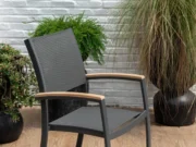 Scaun de grădină Essence din lateral lângă o iarbă decorativă înaltă în ghiveci