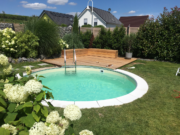 Eingelassener runder Pool MTH Atlantic Round mit sandfarbener Auskleidung in einem Garten mit Hortensien